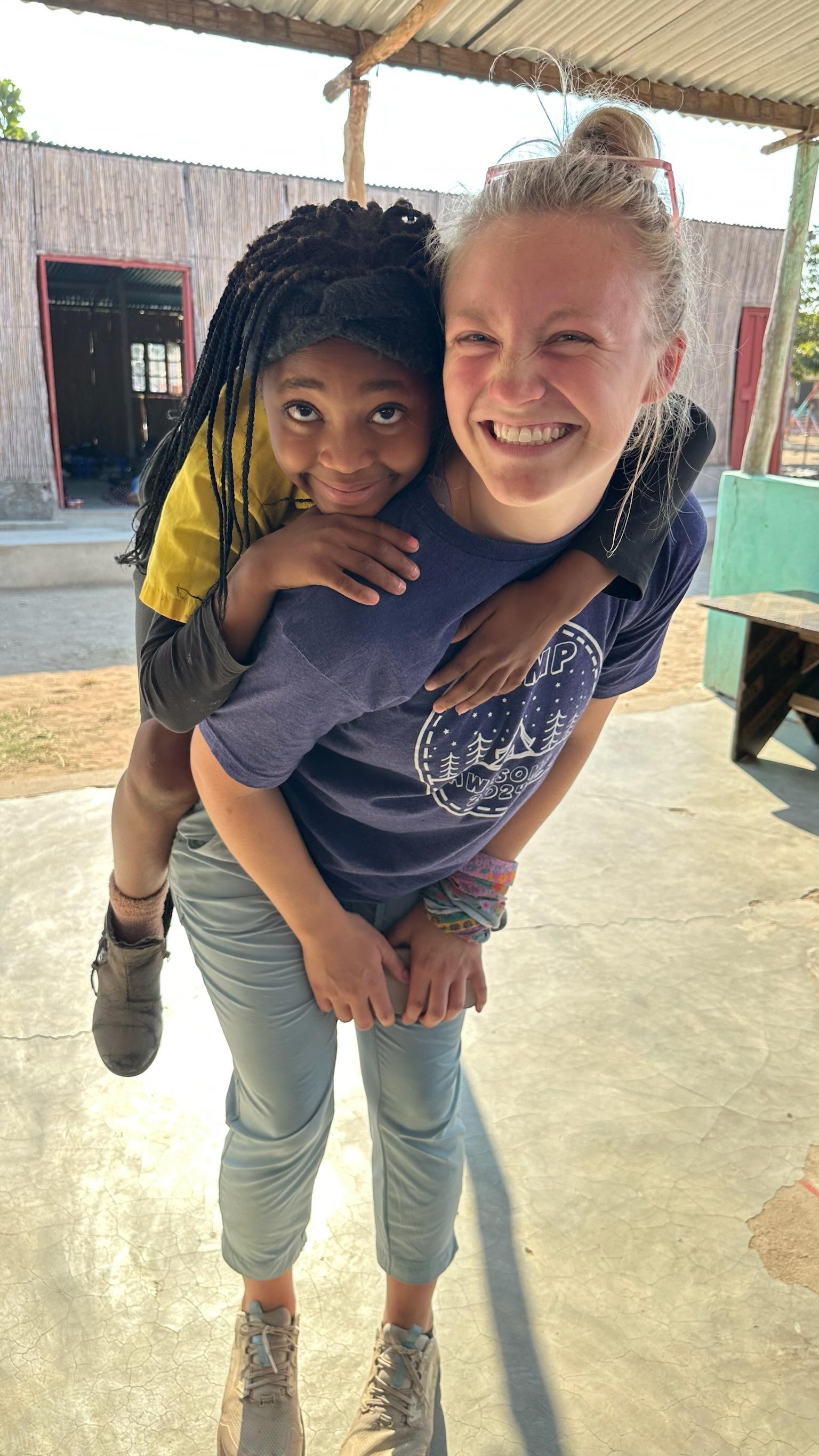 Team member giving a child a piggyback ride